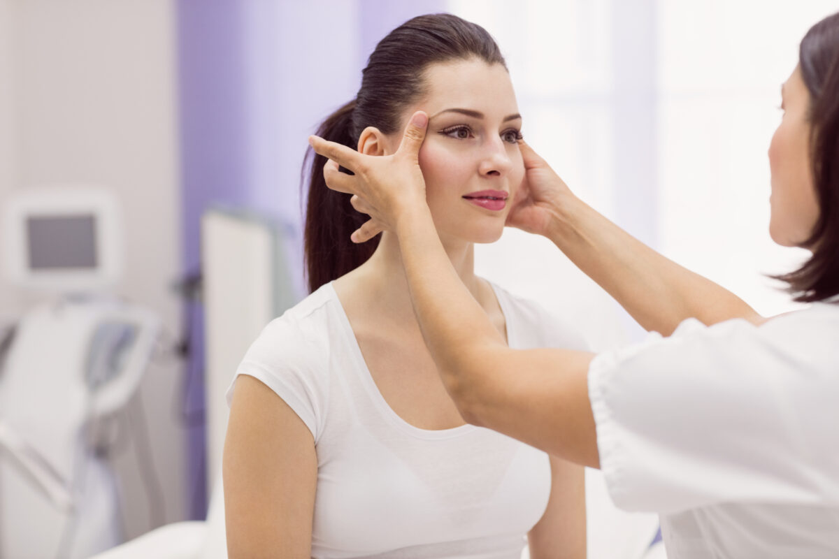 dermatologist examining female patient skin